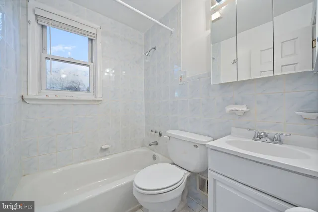 a bathroom with a toilet a sink a bath tub and a mirror