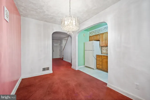 a view of a hallway with wooden floor and a chandelier