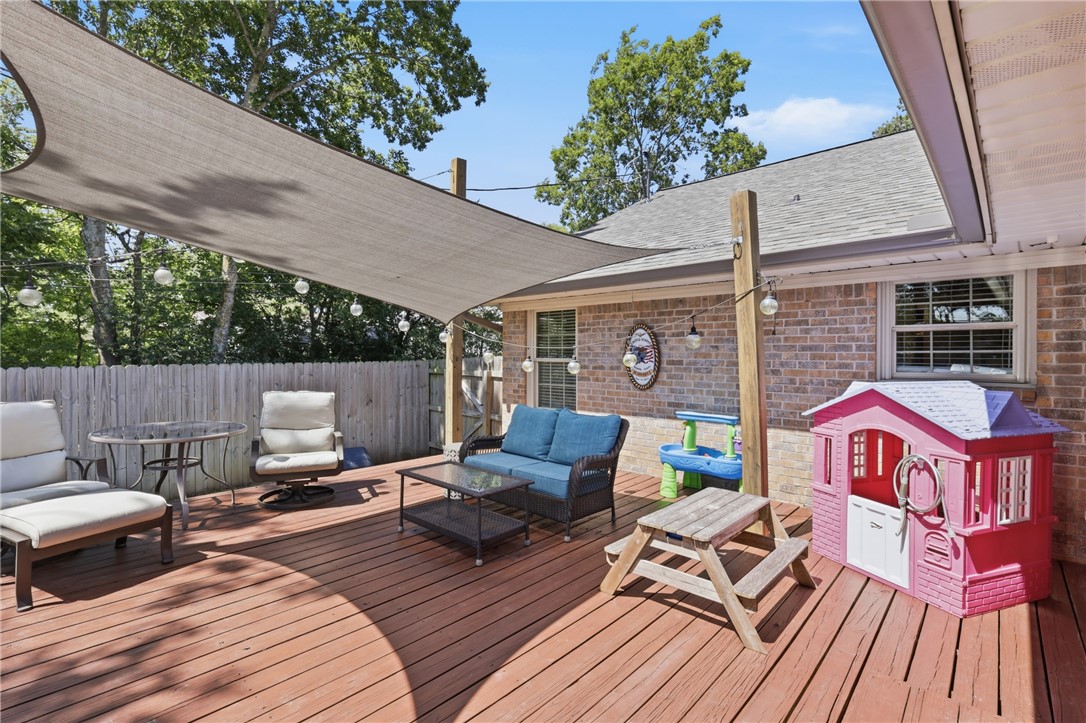 515 Crescent Drive Bryan, TX 77801 - Photo 33 of 43 Expansive wood deck featuring a large shade sail, brick exterior, perimeter fencing, and exterior lighting