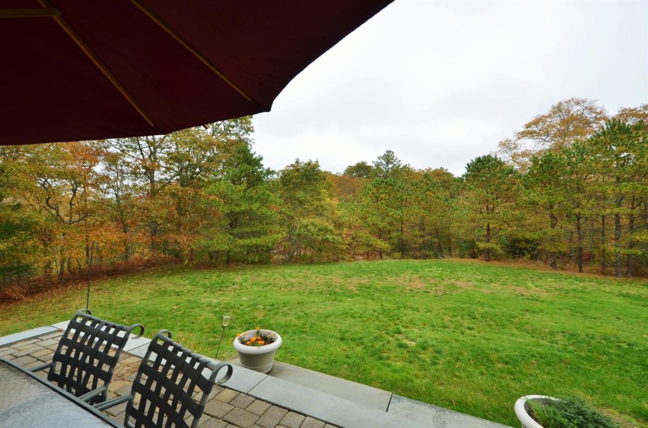 13 Aspen Road Buzzards Bay, MA 02532 - Photo 26 of 29 a view of a backyard with table and chairs under an umbrella
