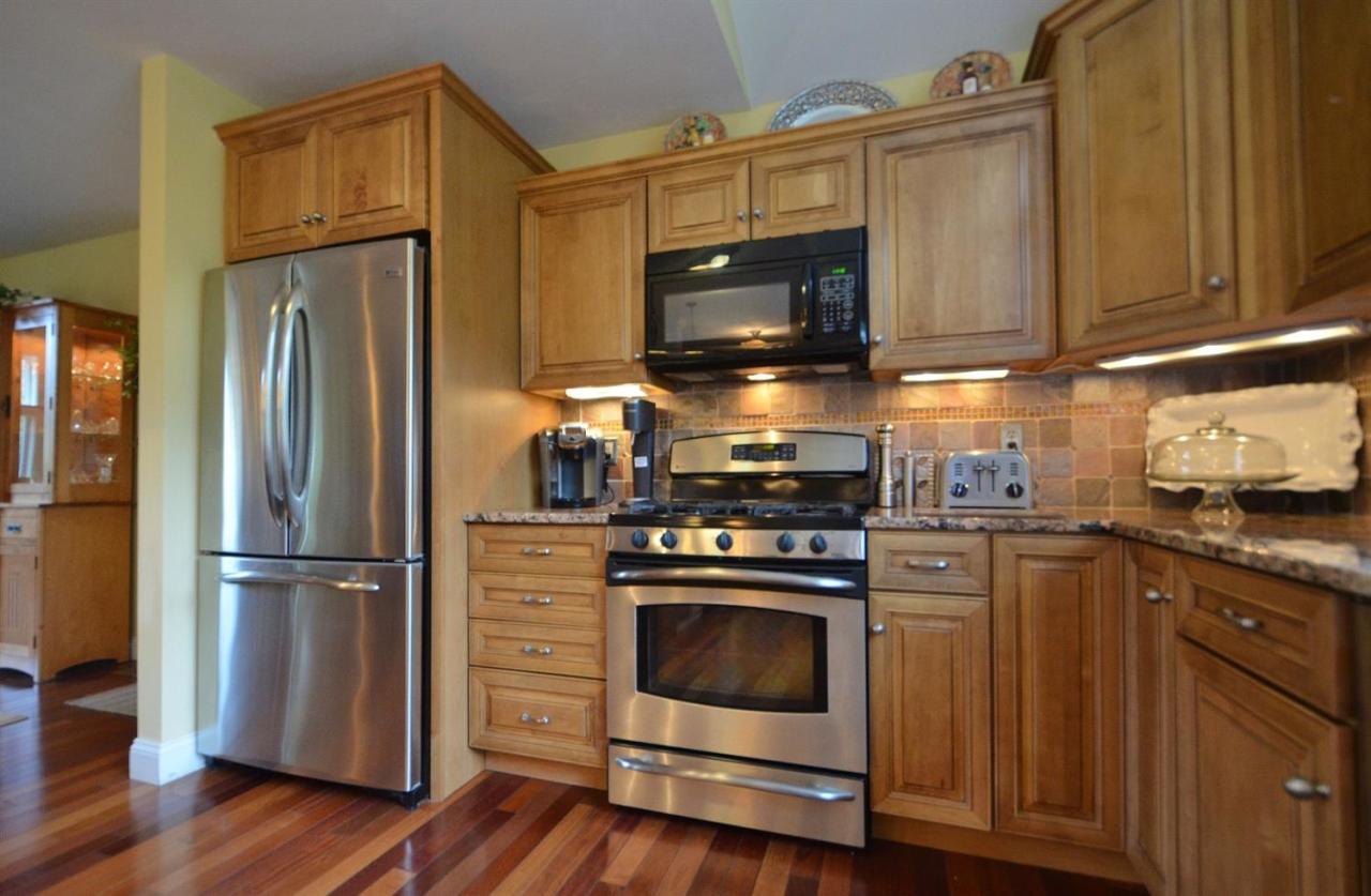 13 Aspen Road Buzzards Bay, MA 02532 - Photo 5 of 29 a kitchen with wooden cabinets and stainless steel appliances