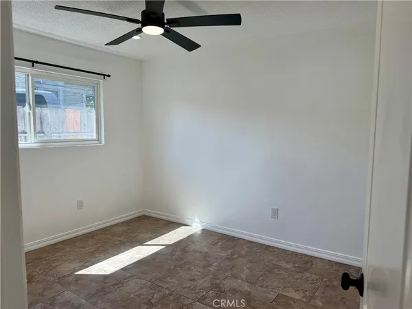 an empty room with a chandelier fan