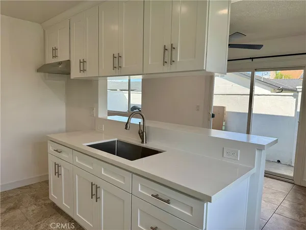 a kitchen with stainless steel appliances granite countertop a sink and a white cabinets