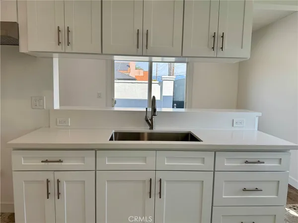 a kitchen with white cabinets and a sink