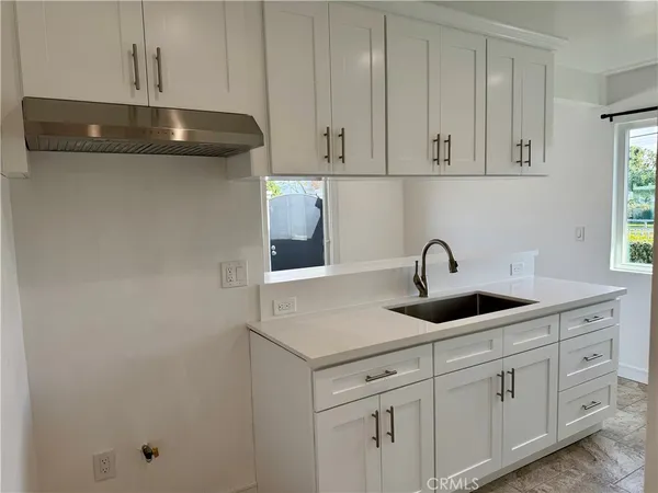 a kitchen with white cabinets and a sink