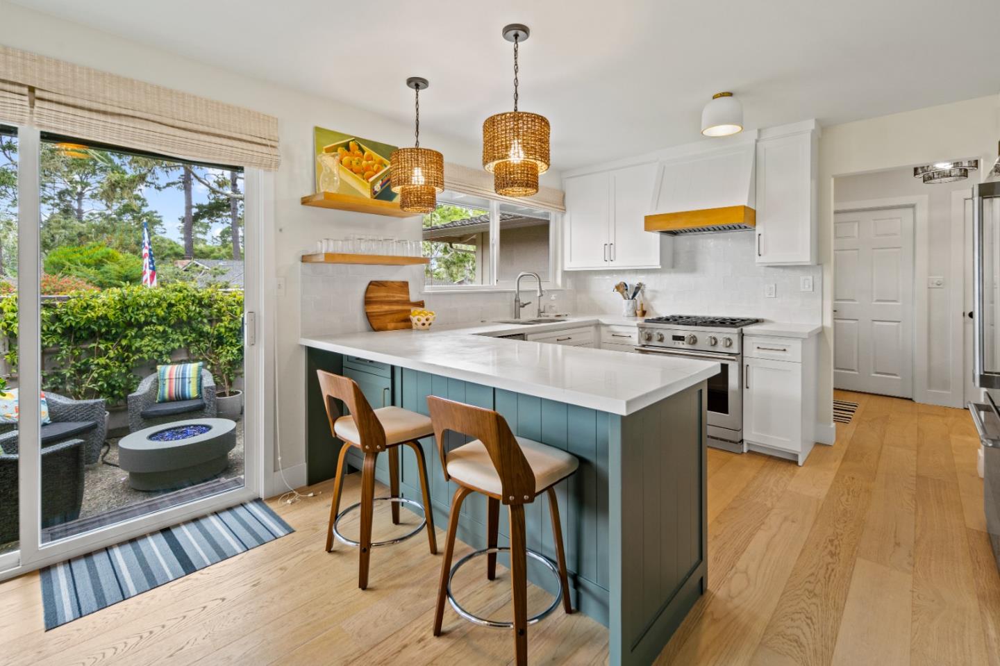 a kitchen with stainless steel appliances granite countertop a stove a sink dishwasher a microwave oven with a dining table and chairs with wooden floor