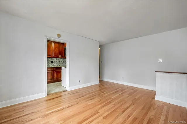 a view of an empty room with wooden floor and closet