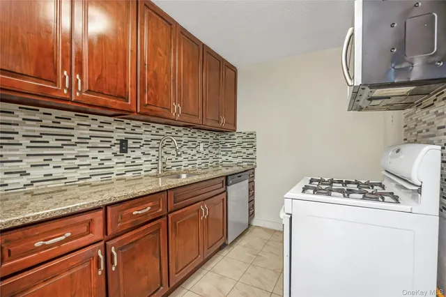 a kitchen with stainless steel appliances granite countertop a sink stove and cabinets