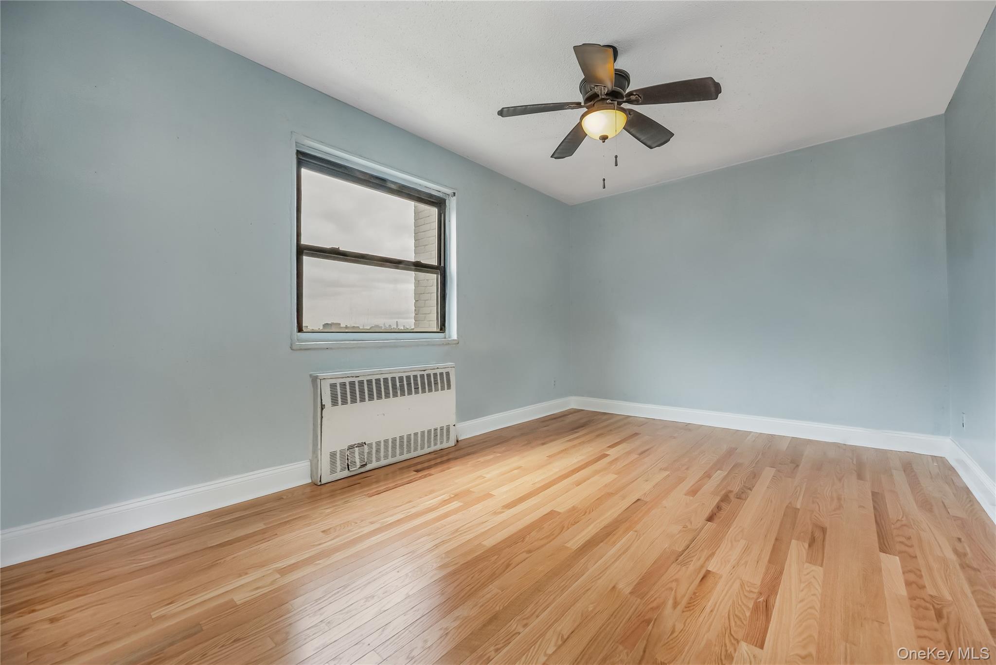 6703 136th Street, Unit B Queens, NY 11367 - Photo 3 of 14 wooden floor in an empty room with a window