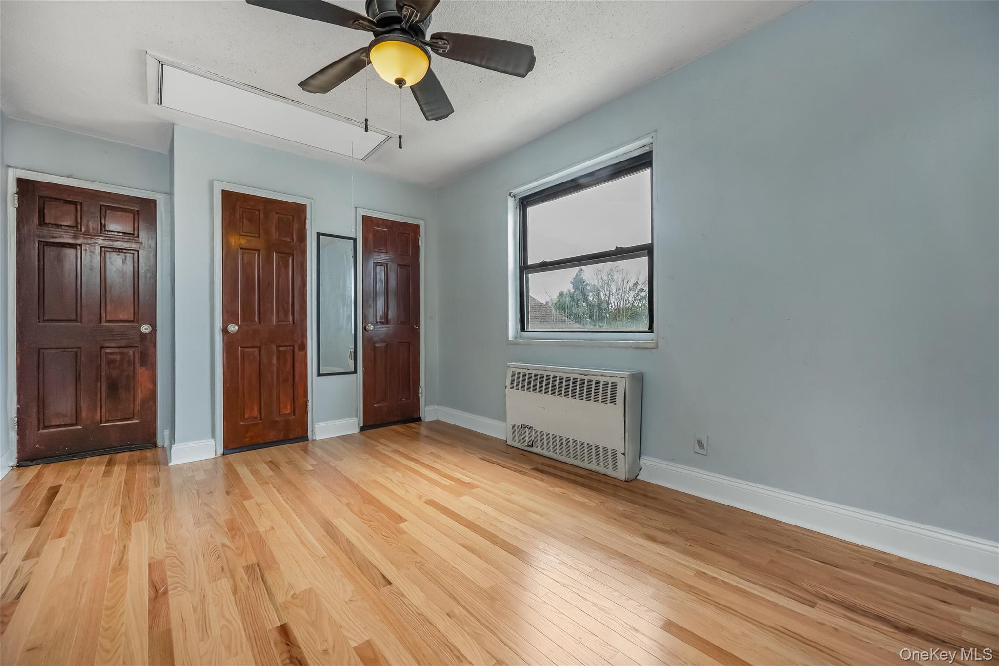 6703 136th Street, Unit B Queens, NY 11367 - Photo 4 of 14 a view of a room with wooden floor and ceiling fan