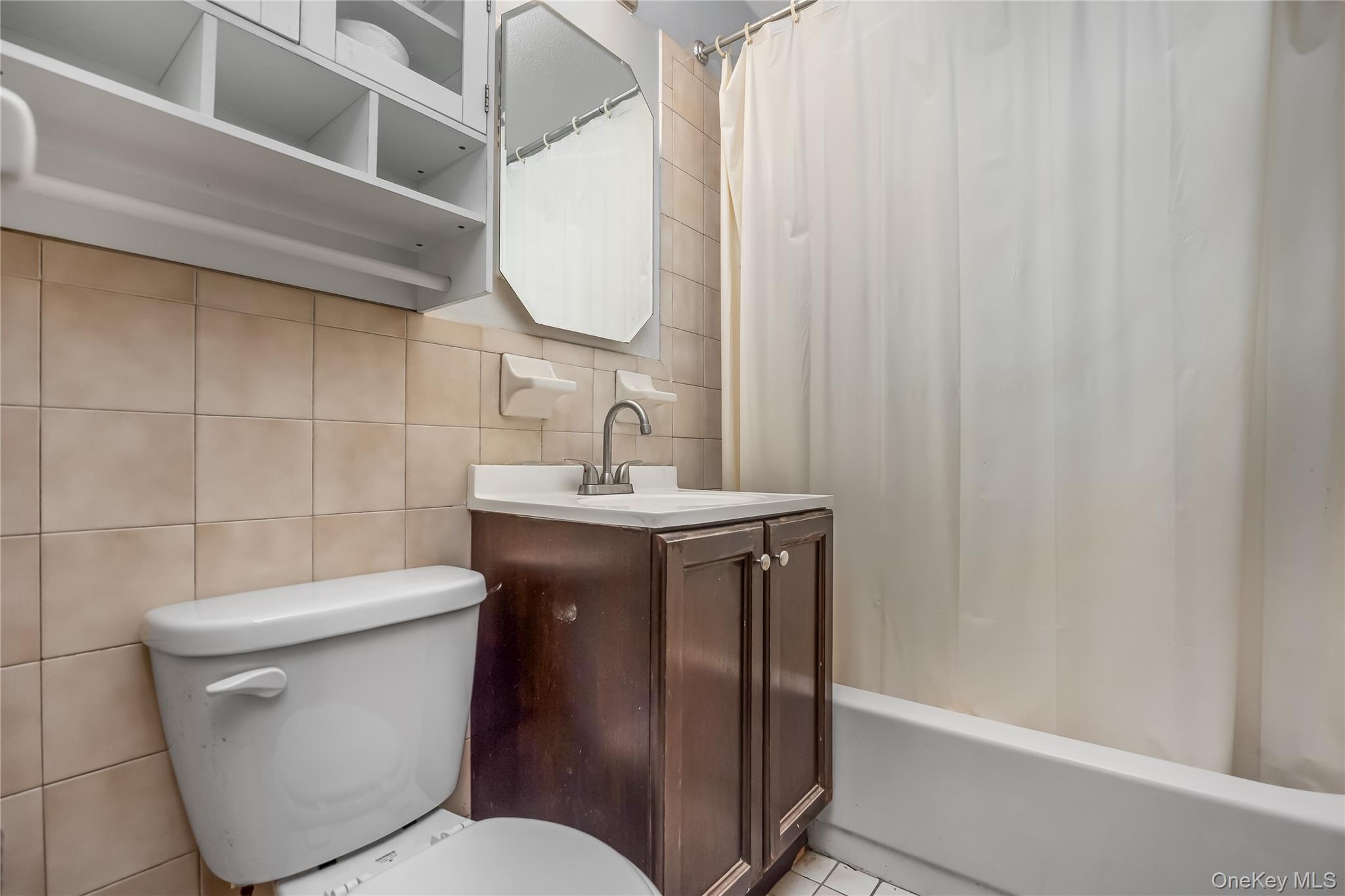 6703 136th Street, Unit B Queens, NY 11367 - Photo 5 of 14 a bathroom with a sink a toilet and a mirror