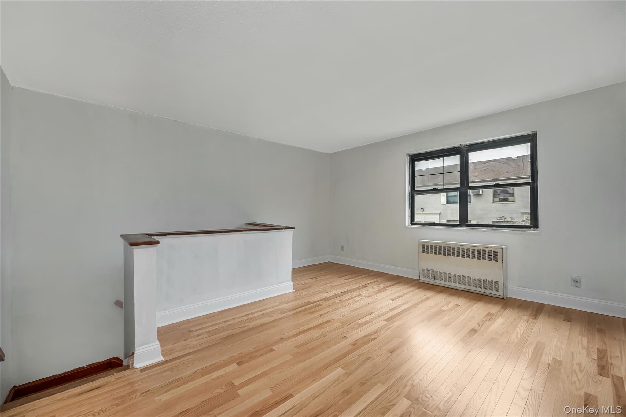 6703 136th Street, Unit B Queens, NY 11367 - Photo 7 of 14 an empty room with wooden floor and windows
