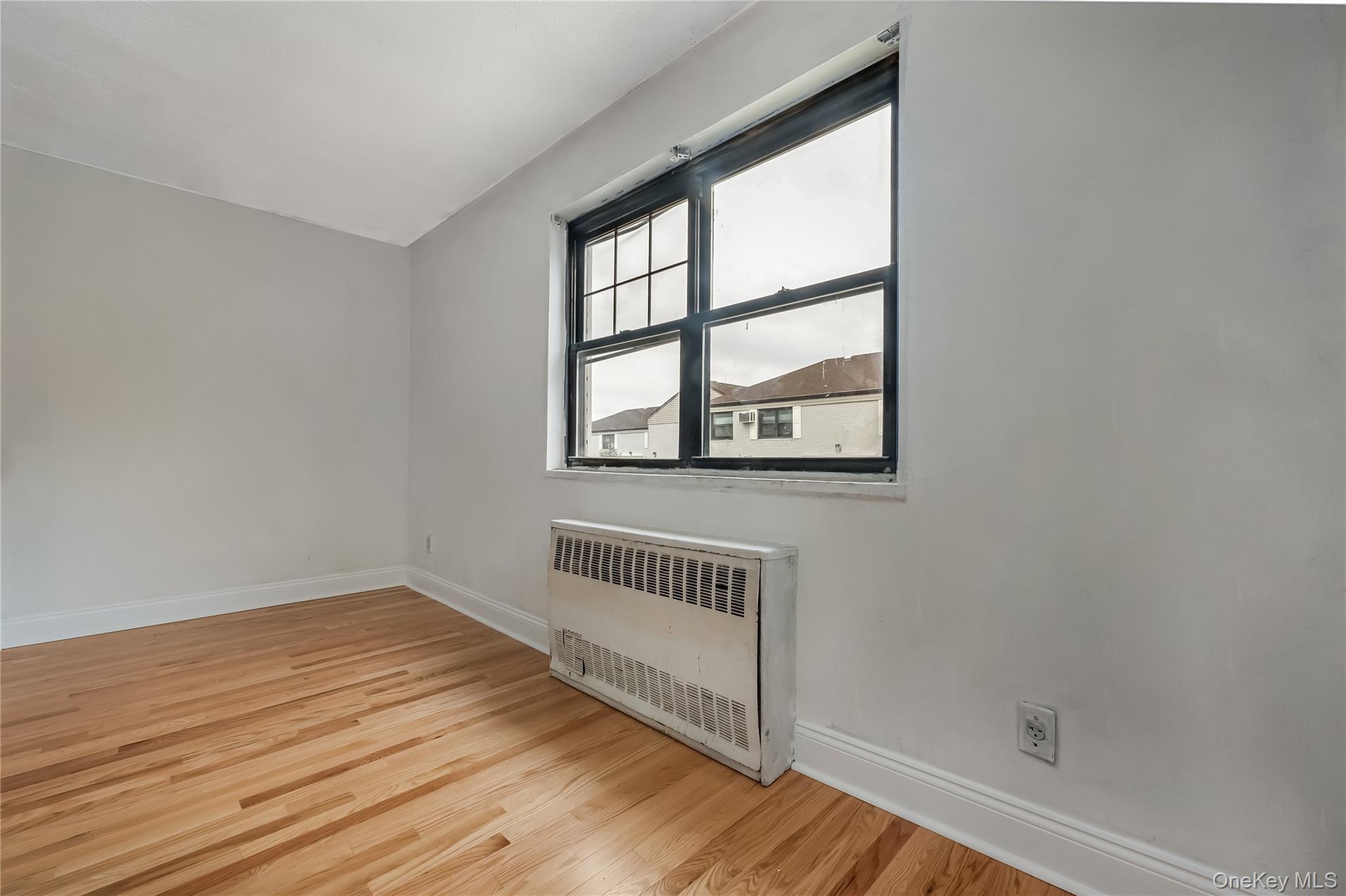 6703 136th Street, Unit B Queens, NY 11367 - Photo 8 of 14 an empty room with wooden floor and windows