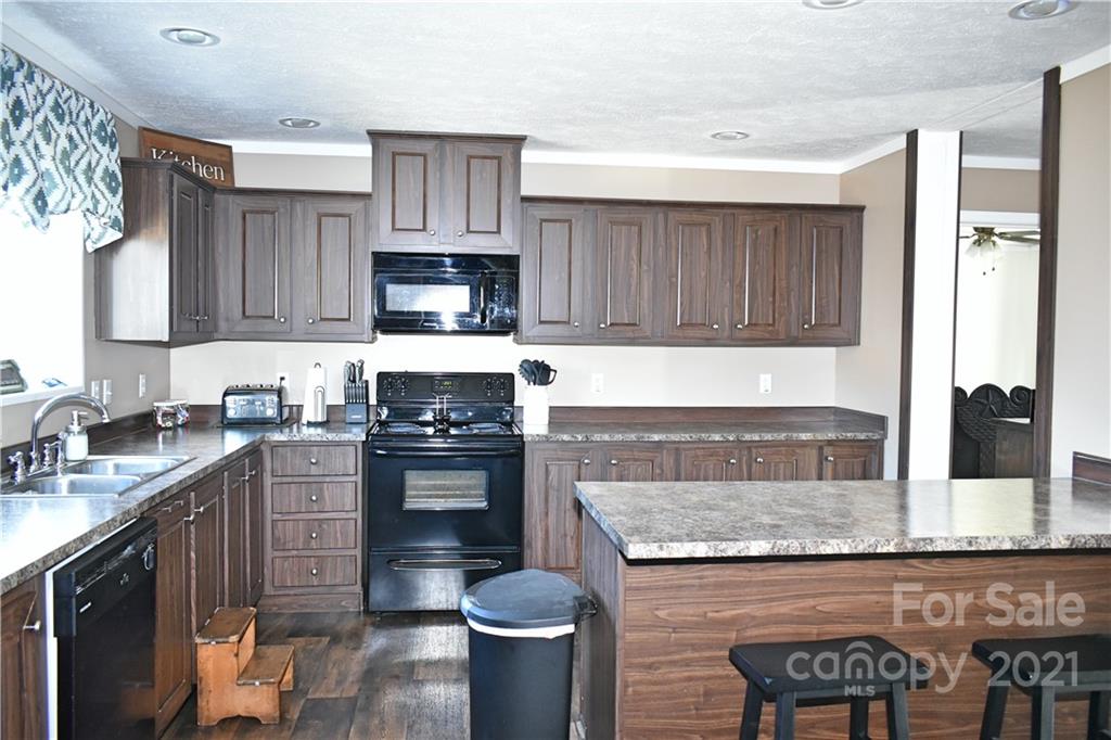 11 Fernwood Road Clyde, NC 28721 - Photo 9 of 26 a kitchen with kitchen island granite countertop a sink stove and cabinets
