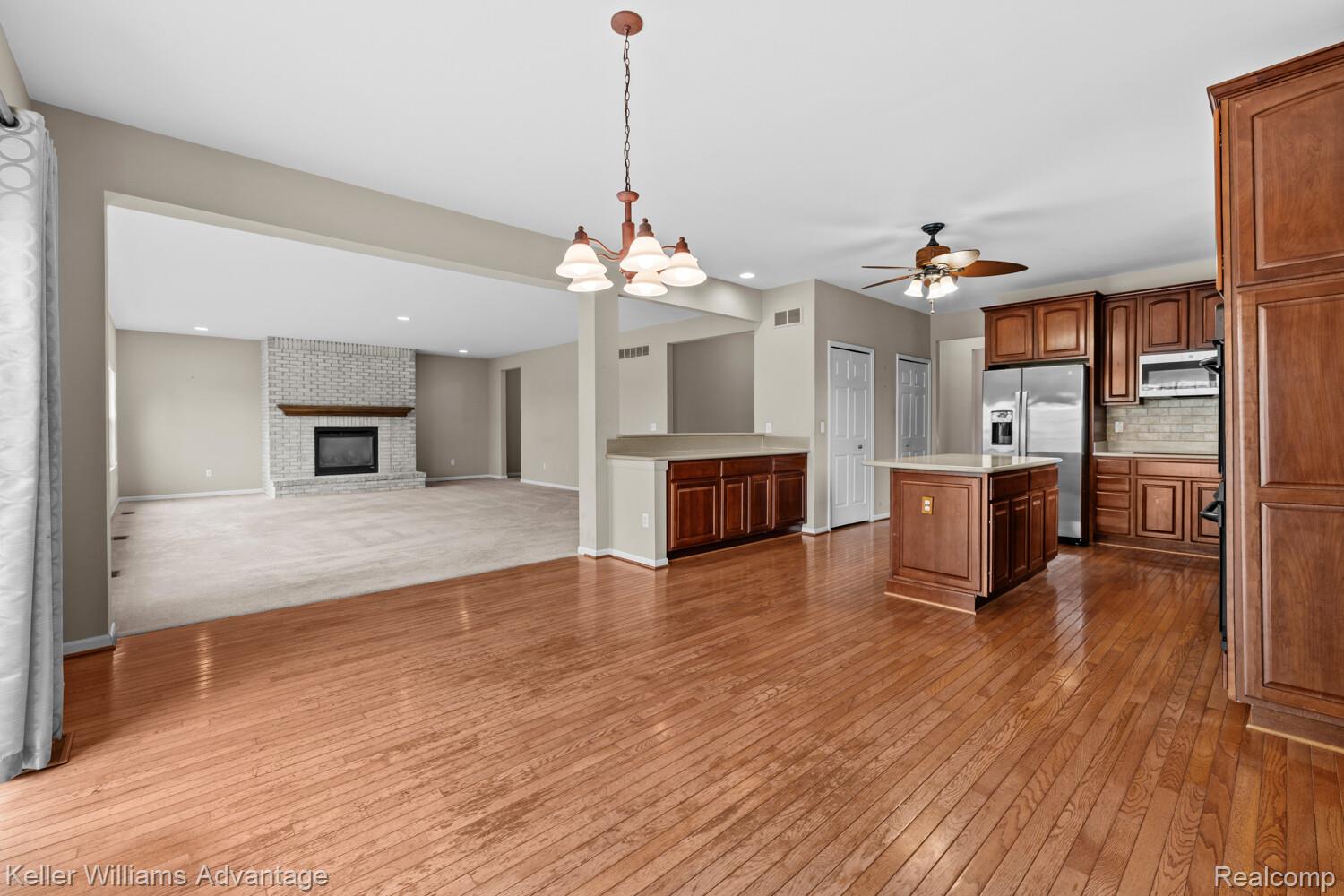 4100 Norwich Court Rochester, MI 48306 - Photo 72 of 72 Kitchen with open floor plan, light countertops, a brick fireplace, stainless steel appliances, and dark wood-style floors