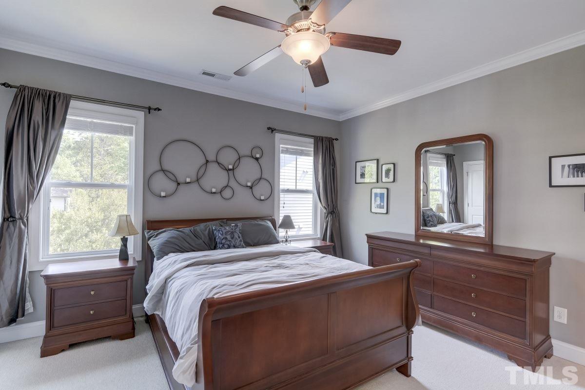 527 Ledbetter Court Raleigh, NC 27608 - Photo 8 of 13 a bedroom with a large bed and a chandelier
