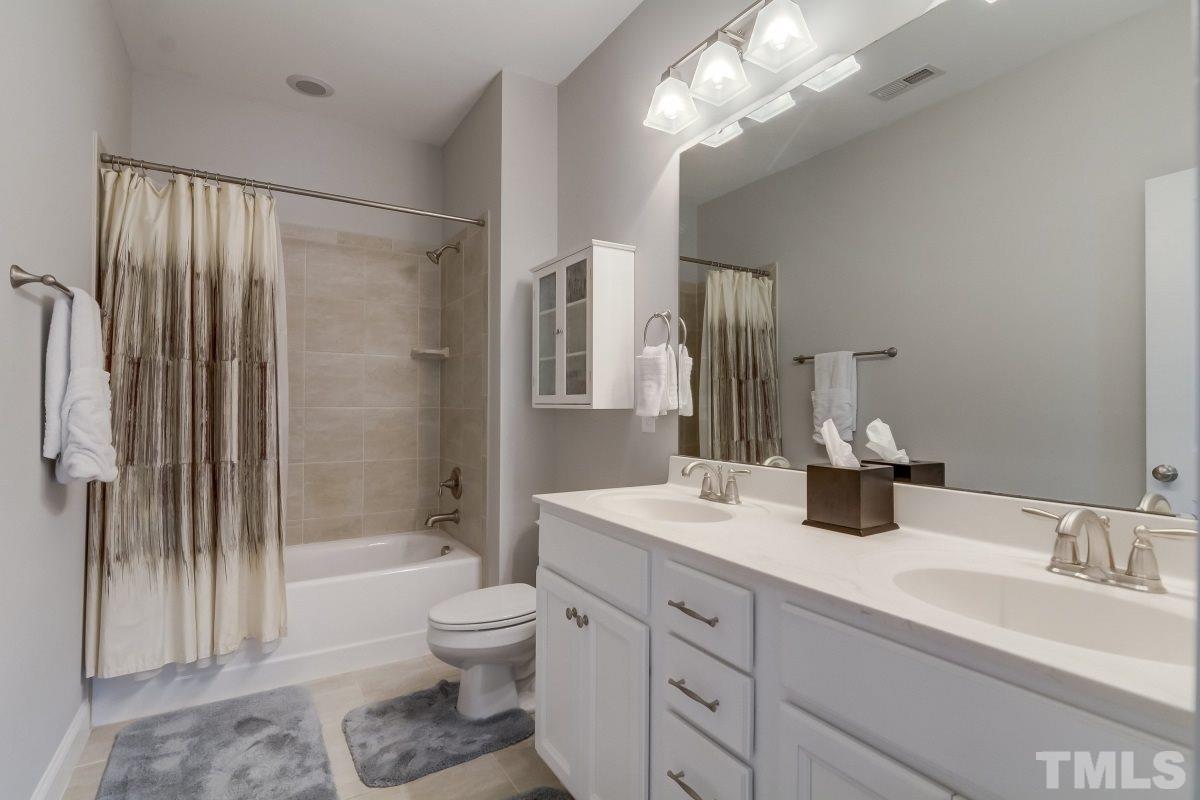527 Ledbetter Court Raleigh, NC 27608 - Photo 10 of 13 a bathroom with a double vanity sink toilet mirror and shower