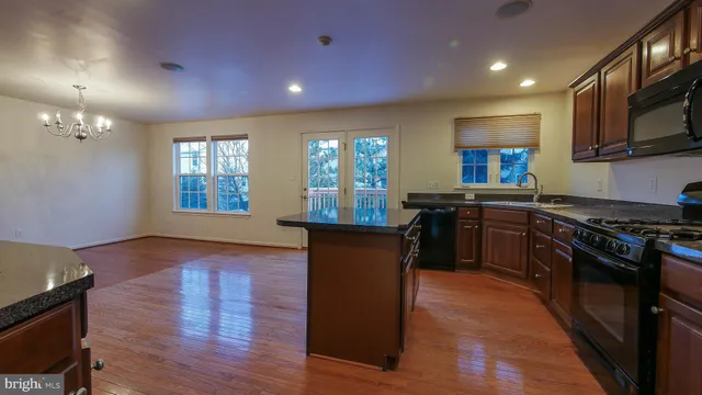 a kitchen with granite countertop wooden floors and stainless steel appliances