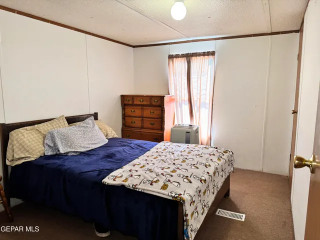 a bedroom with a bed next to a window