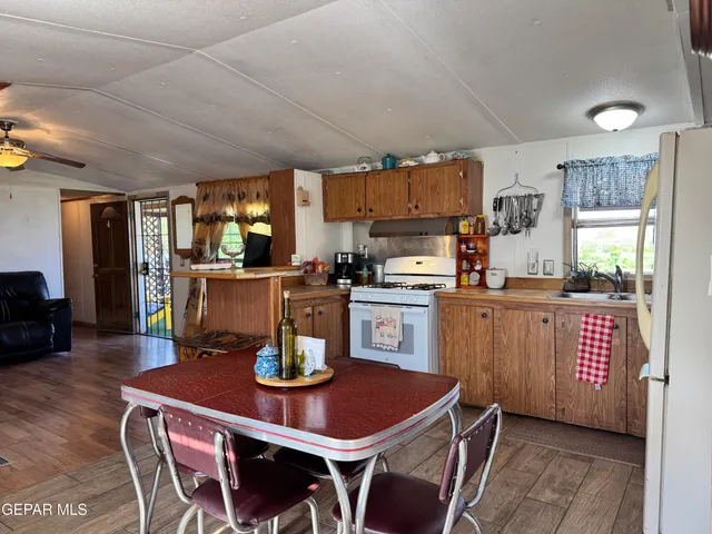a kitchen with a dining table chairs and refrigerator