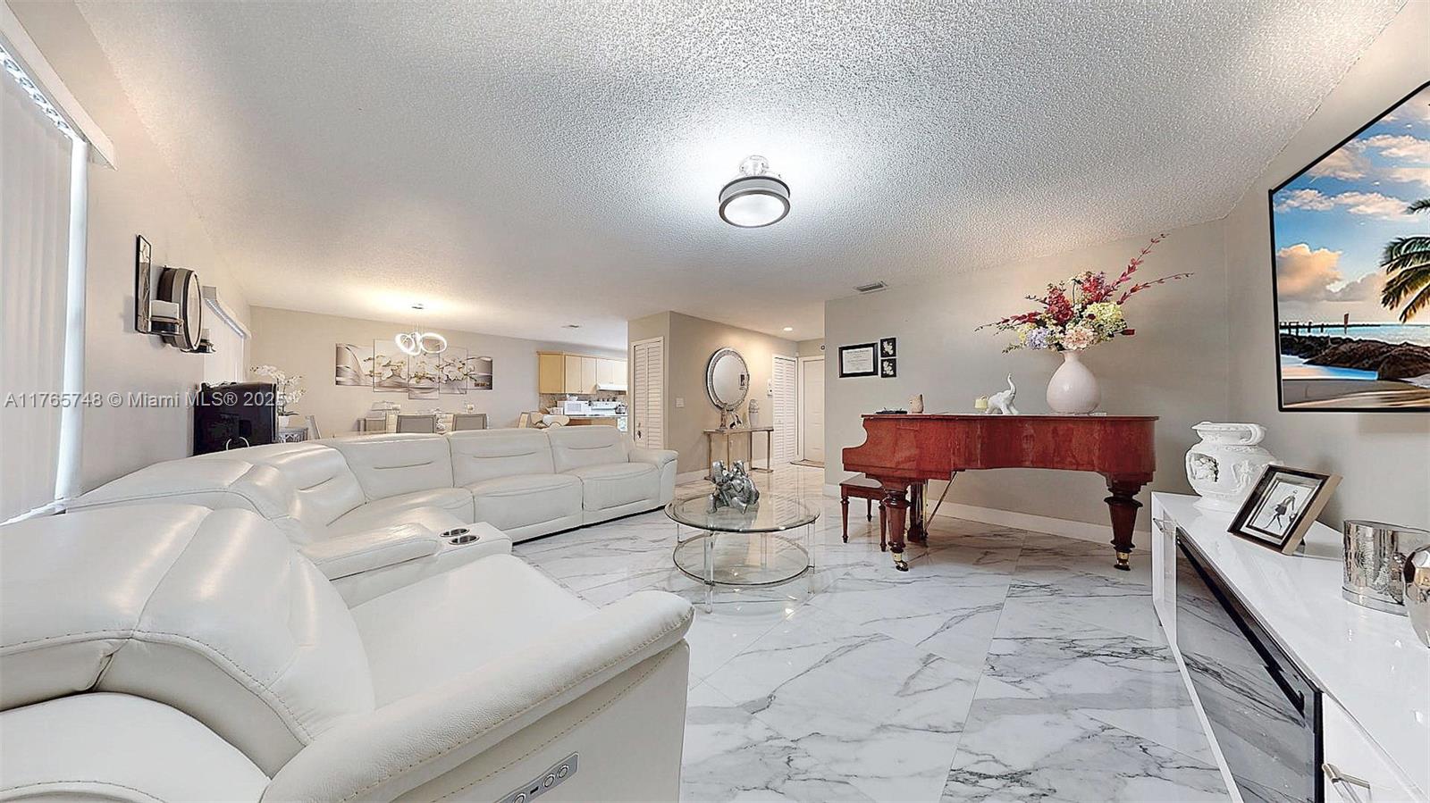 13539 Southwest 62nd Street, Unit 1 Miami, FL 33183 - Photo 11 of 38 a living room with furniture and a chandelier