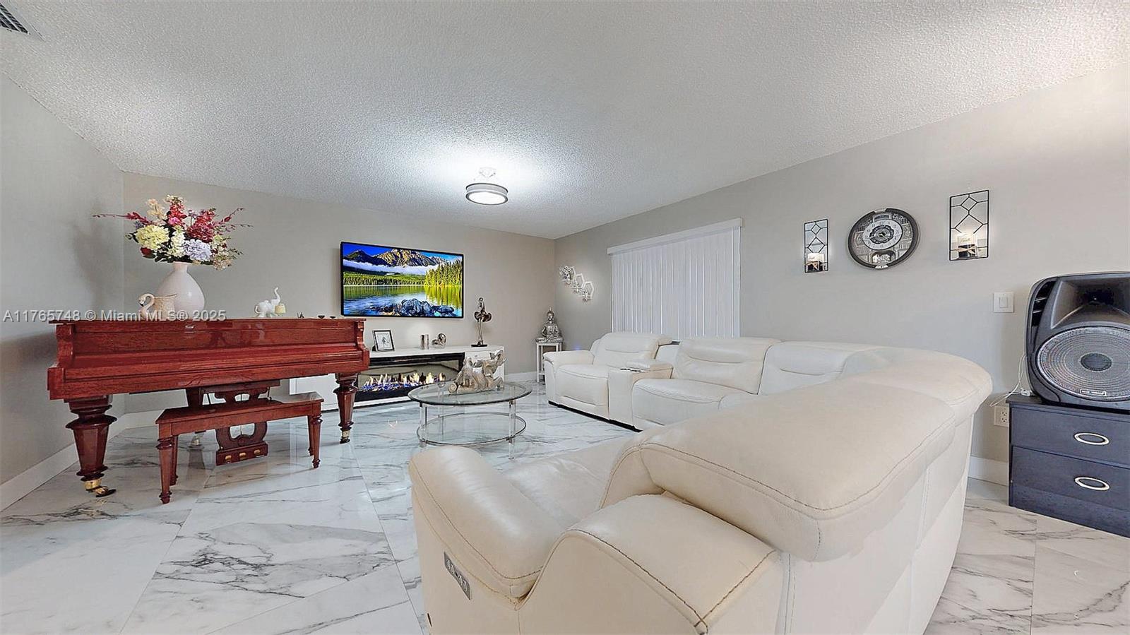 13539 Southwest 62nd Street, Unit 1 Miami, FL 33183 - Photo 12 of 38 a living room with furniture and a flat screen tv