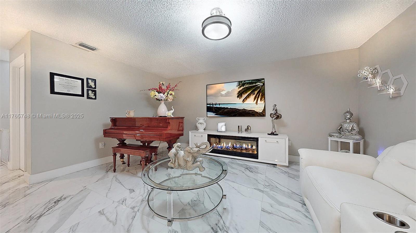 13539 Southwest 62nd Street, Unit 1 Miami, FL 33183 - Photo 14 of 38 a living room with furniture a fireplace and a flat screen tv