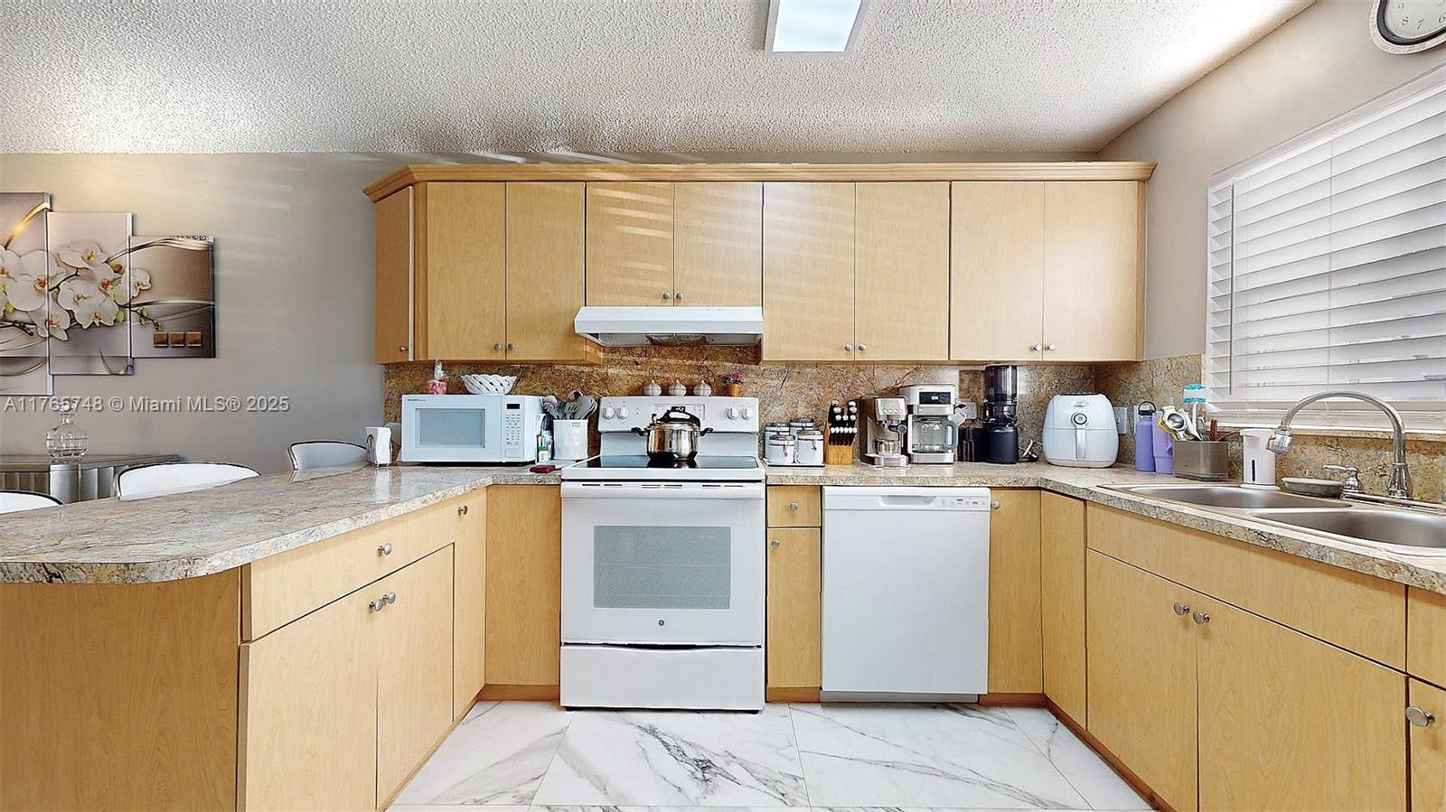13539 Southwest 62nd Street, Unit 1 Miami, FL 33183 - Photo 20 of 38 a kitchen with a sink white cabinets and white appliances