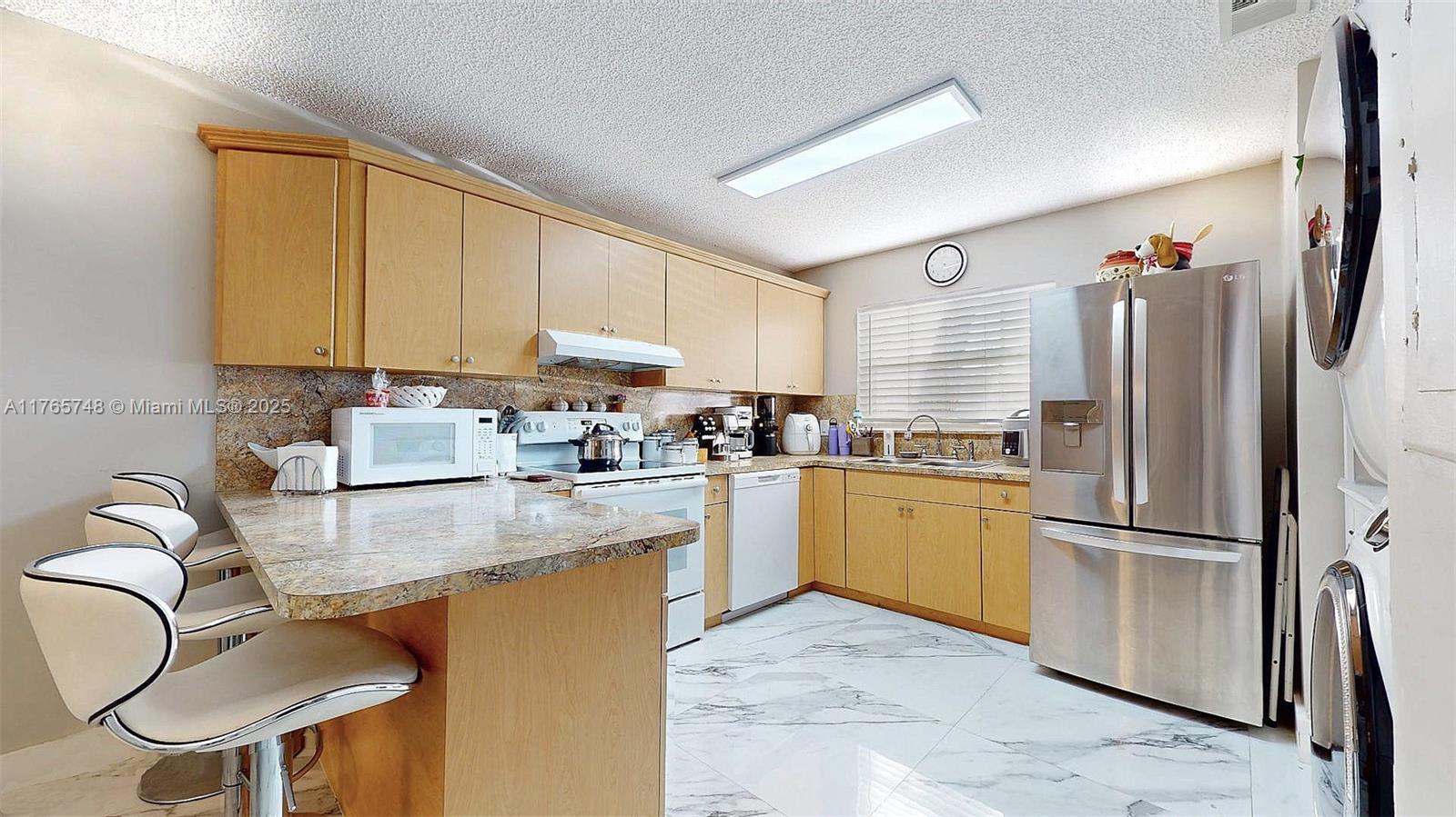 13539 Southwest 62nd Street, Unit 1 Miami, FL 33183 - Photo 21 of 38 a kitchen with stainless steel appliances granite countertop a refrigerator a sink dishwasher a stove with white cabinets and wooden floor