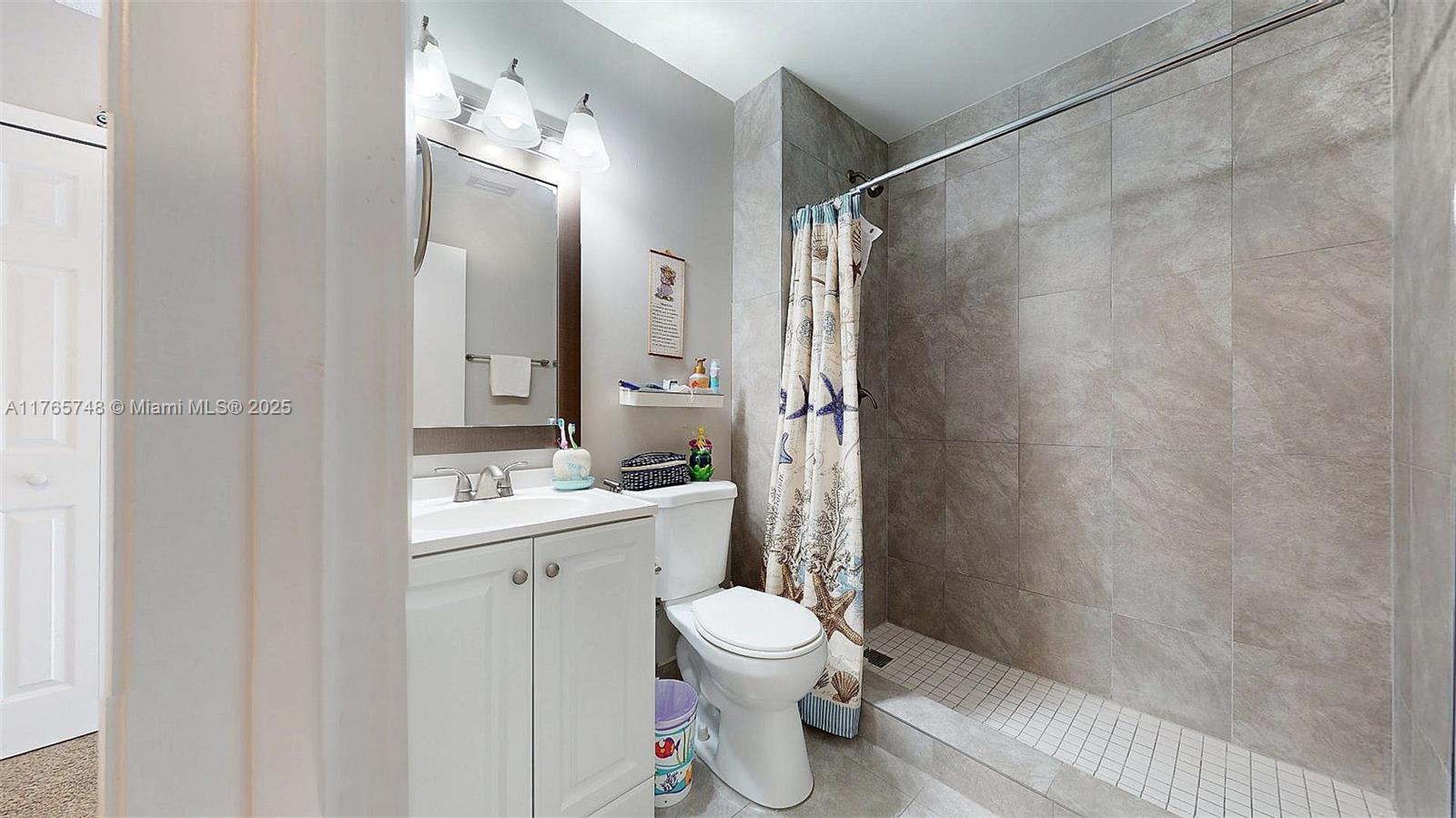 13539 Southwest 62nd Street, Unit 1 Miami, FL 33183 - Photo 31 of 38 a bathroom with a toilet sink and shower