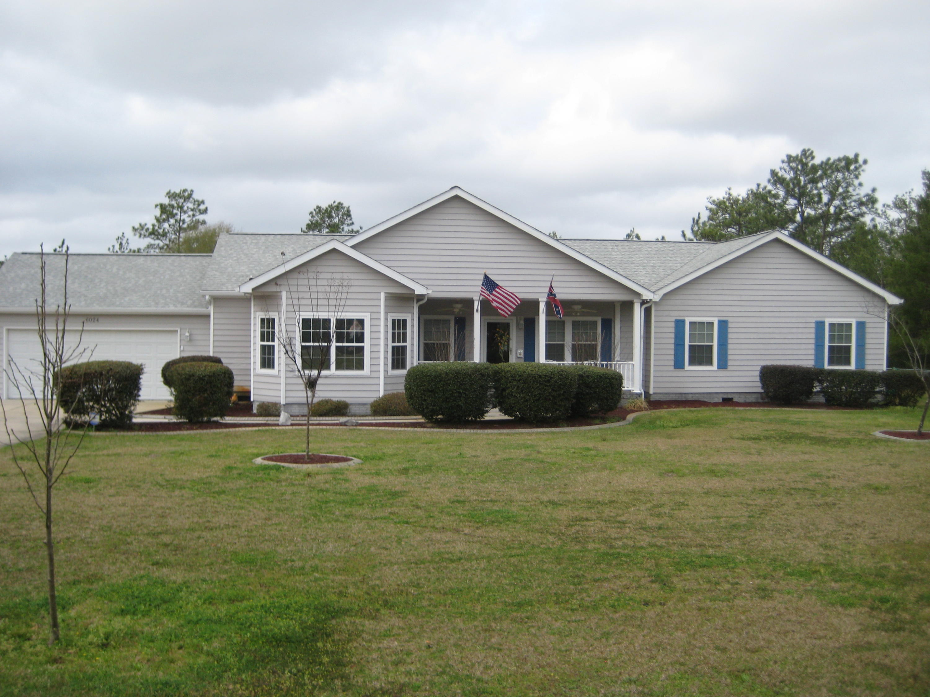 6024 Sand Hill Road Crestview, FL 32539 - Photo 1 of 43 a front view of a house with a garden