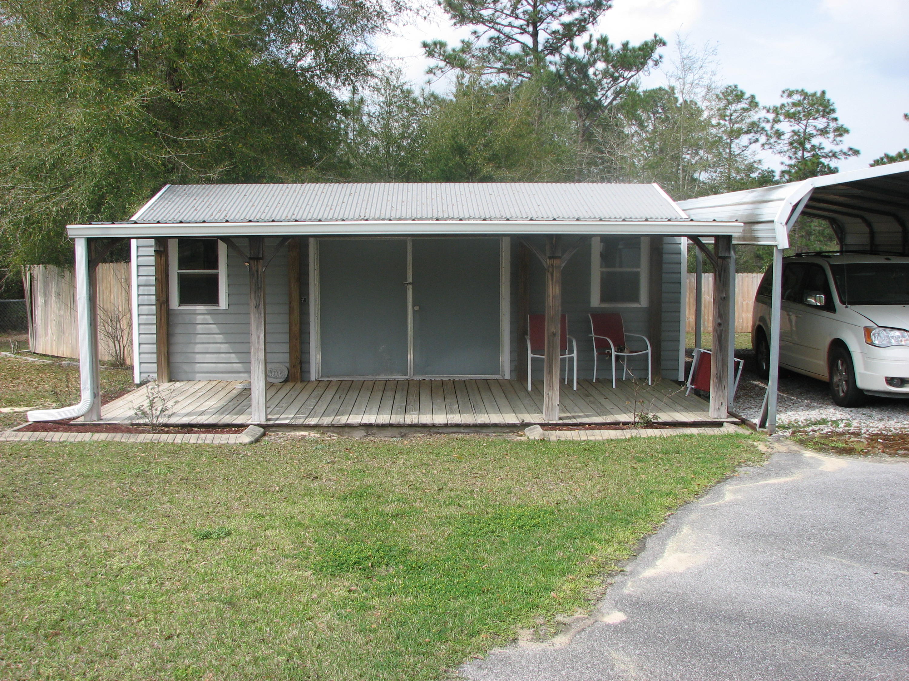 6024 Sand Hill Road Crestview, FL 32539 - Photo 3 of 43 a front view of a house with a yard table and chairs