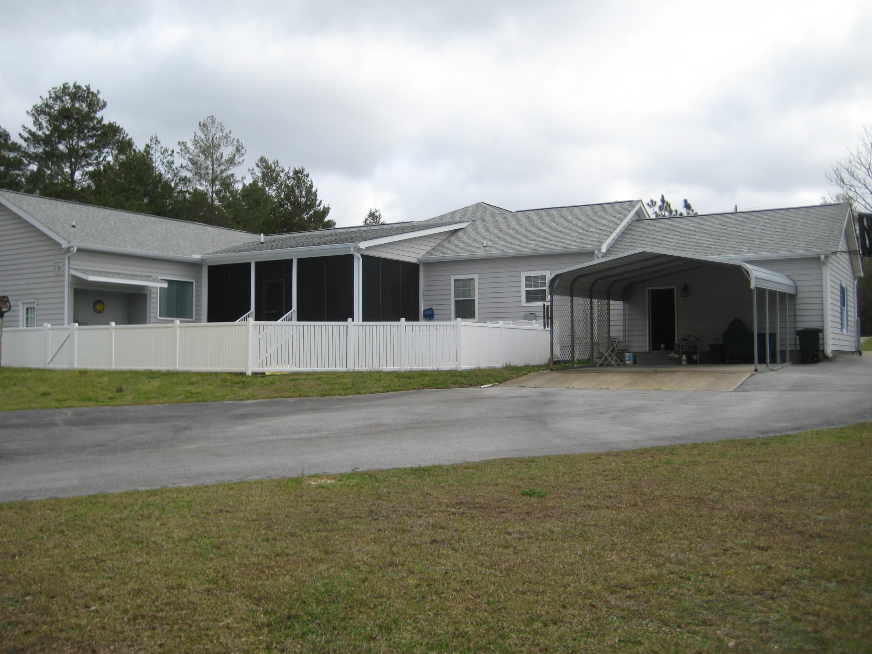 6024 Sand Hill Road Crestview, FL 32539 - Photo 8 of 43 a front view of a house with a garden and yard