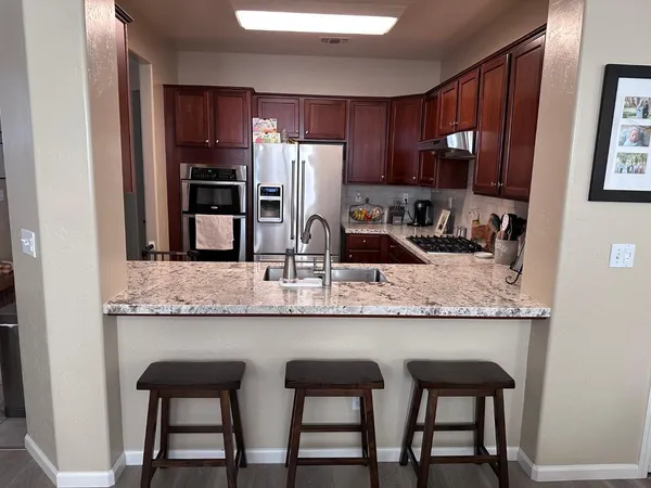 a kitchen with granite countertop kitchen island cabinets and refrigerator