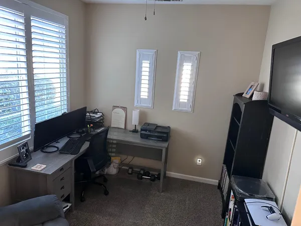 a view of a workspace with furniture and a window