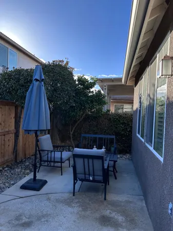 a backyard of a house with table and chairs