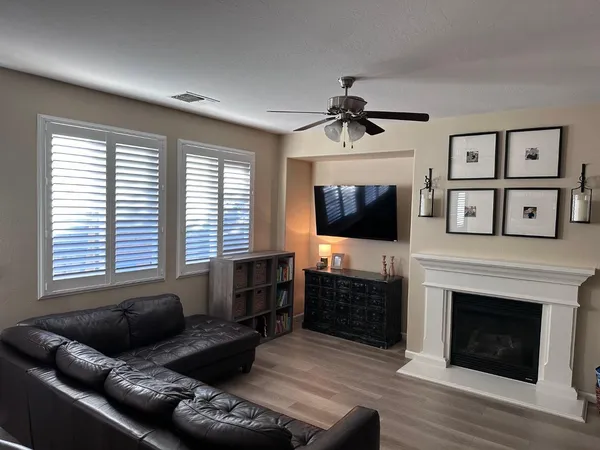 a living room with furniture a flat screen tv and a fireplace