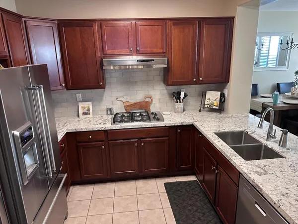 a kitchen with granite countertop wooden cabinets and a sink