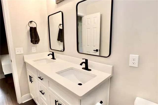 a bathroom with 2 sink and a mirror