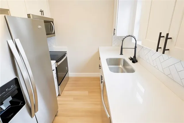 a kitchen with stainless steel appliances a sink and a refrigerator