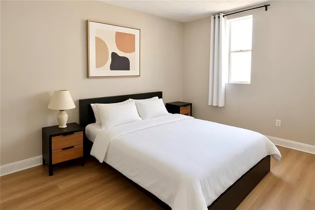 a large bed sitting in a bedroom next to a window