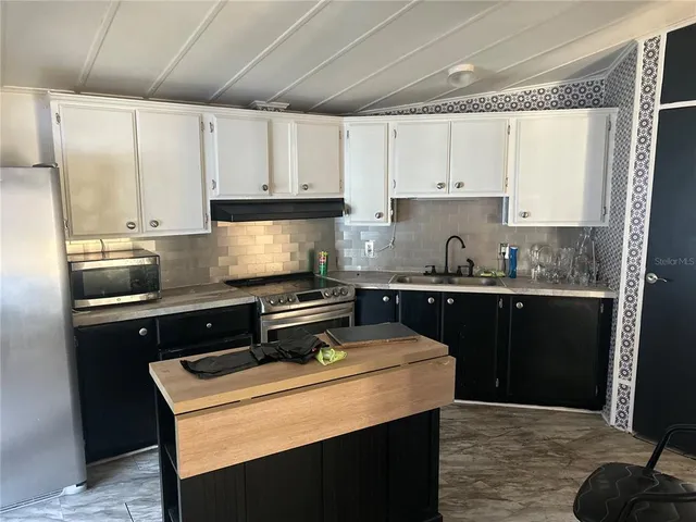 a kitchen with stainless steel appliances granite countertop a stove a sink and a refrigerator