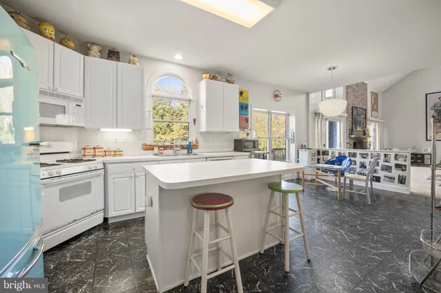 a kitchen with a dining table chairs and white appliances