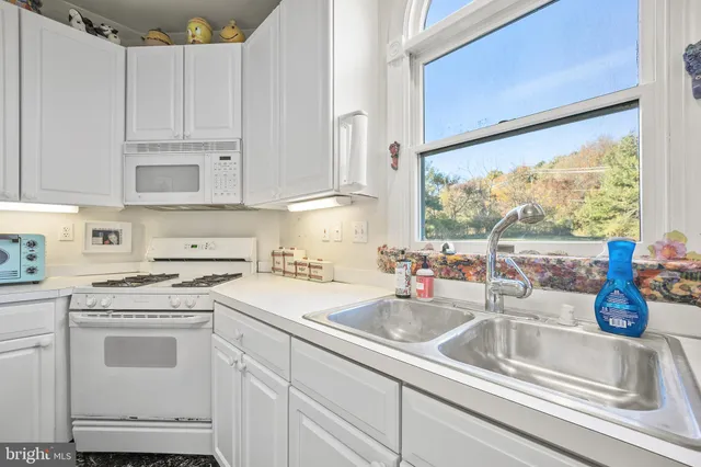 a kitchen with white cabinets and white appliances