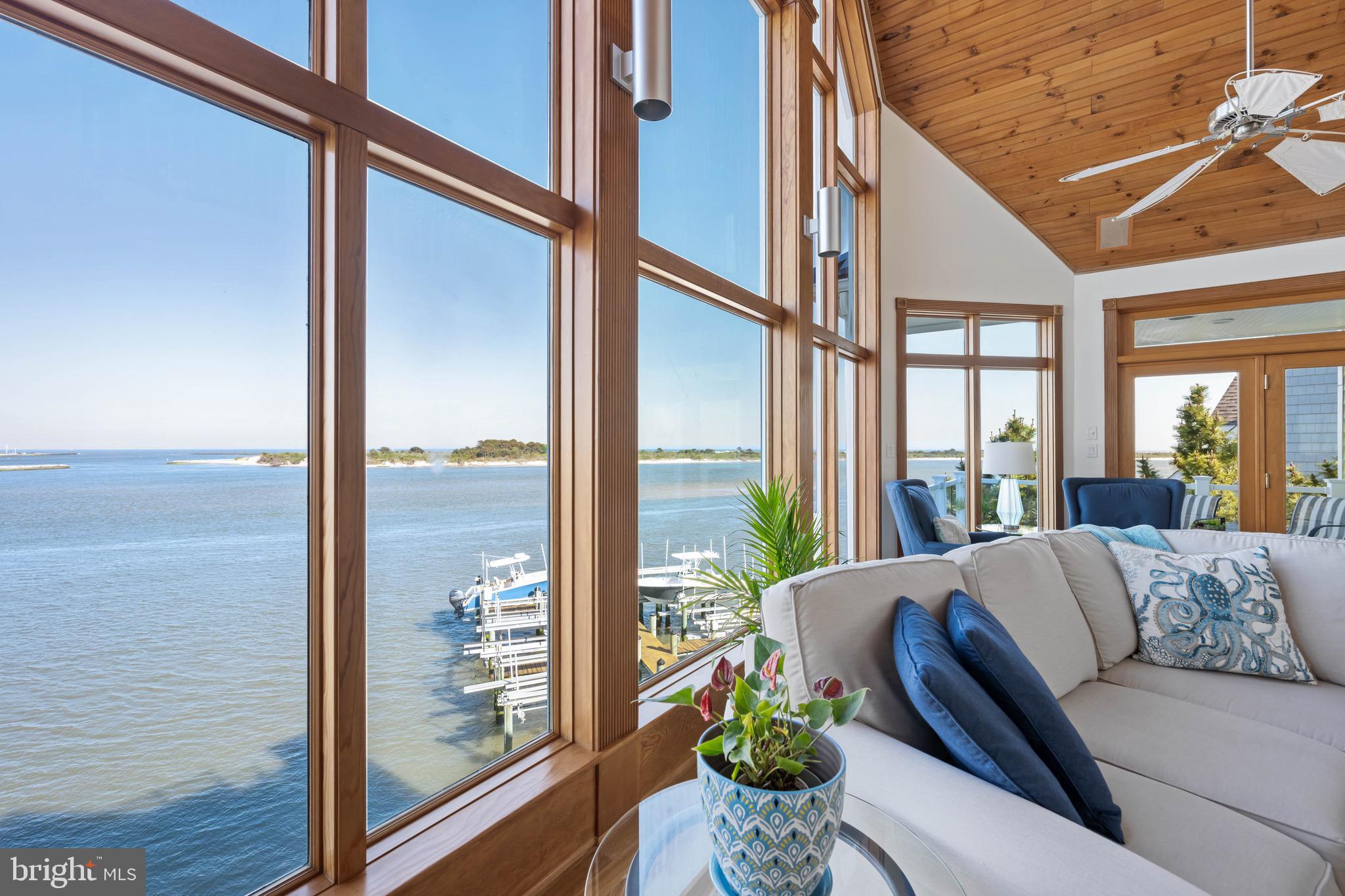 12959 Harbor Road Ocean City, MD 21842 - Photo 9 of 85 a living room with furniture and floor to ceiling windows