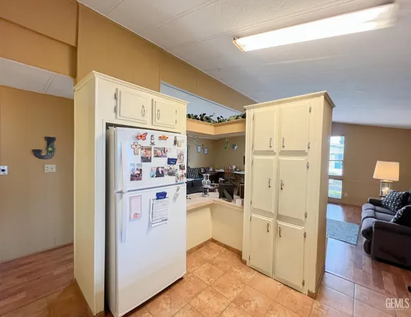 a kitchen with a refrigerator and white cabinets