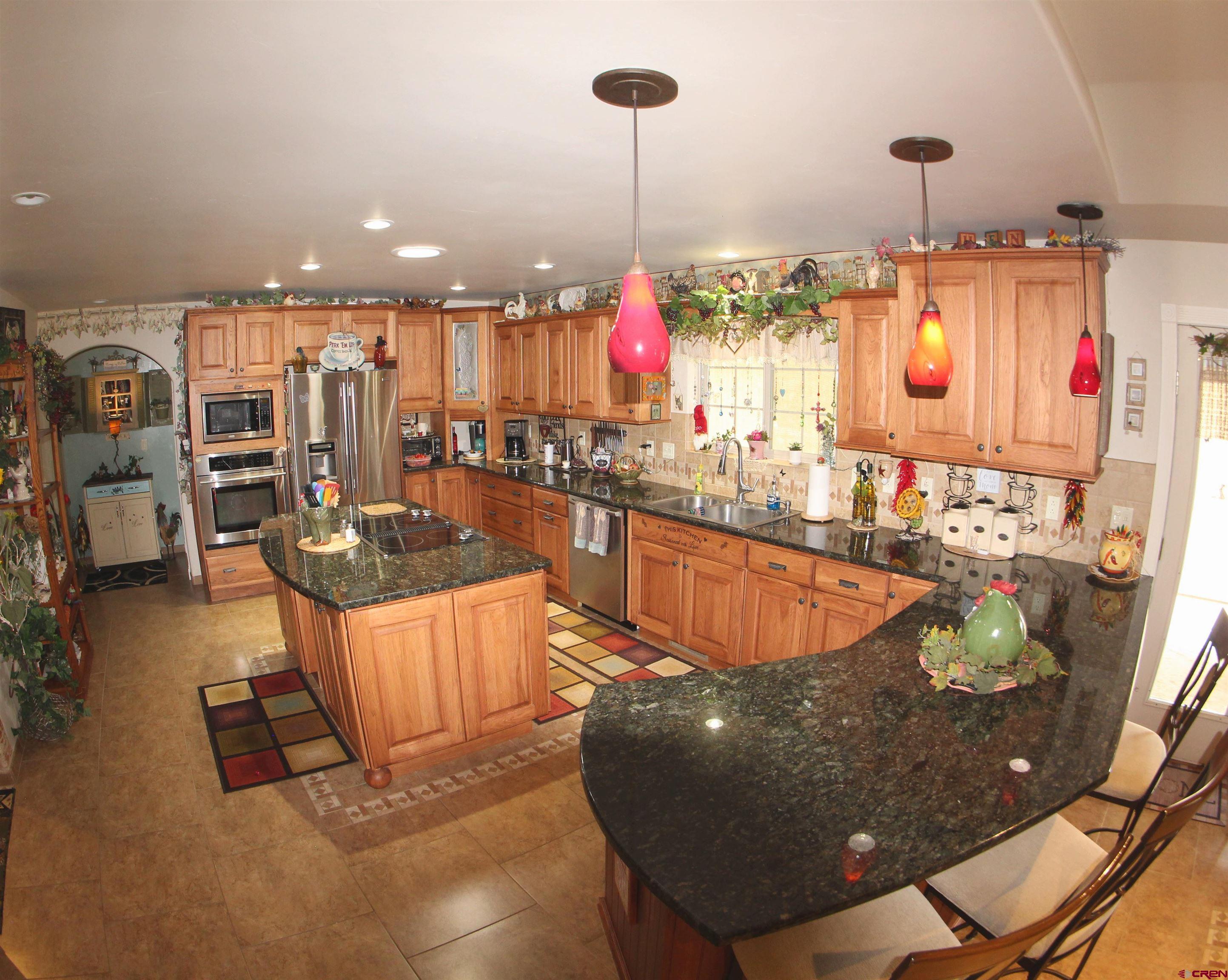 635 Northeast 2nd Street Cedaredge, CO 81413 - Photo 11 of 33 a kitchen with stainless steel appliances kitchen island granite countertop a stove and cabinets