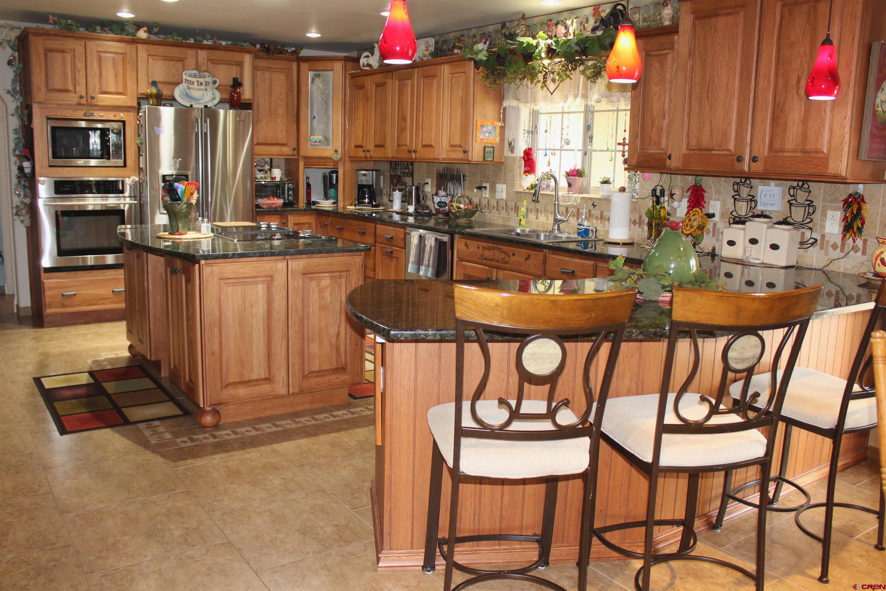 635 Northeast 2nd Street Cedaredge, CO 81413 - Photo 12 of 33 a kitchen with a dining table chairs and a refrigerator