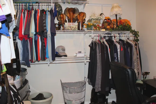 a view of walk in closet with clothes and shoes