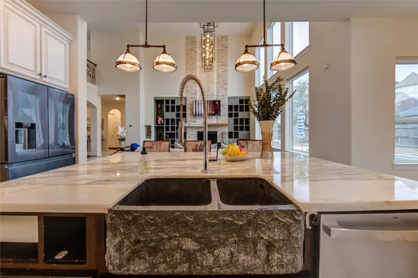 a kitchen view with granite countertop a sink and a clock on the wall